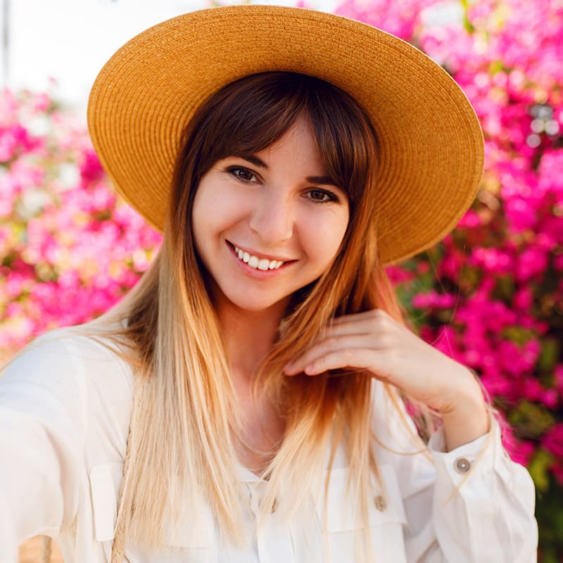 Marija P sa šeširom u cvetnom okruženju – zadovoljna kupovina Fortis vrata